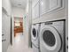 Convenient laundry area with a full-size, stacked washer and dryer set and white cabinets for storage at 2620 Persimmon Loop, The Villages, FL 32162