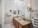 Main bathroom with double sinks, granite counters, mirrors and ample lighting creating a functional space at 2620 Persimmon Loop, The Villages, FL 32162
