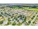 An aerial shot of a residential area featuring well-maintained homes, green spaces, and a roadway at 2746 Edwards Ln, The Villages, FL 32162