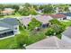 Aerial view of a home's backyard featuring lush green grass, mature trees, and a screened-in patio at 2746 Edwards Ln, The Villages, FL 32162