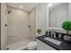 Luxurious bathroom featuring tiled walk-in shower, sleek vanity with elegant fixtures and decor at 2746 Edwards Ln, The Villages, FL 32162