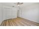 Well-lit bedroom featuring wood-look floors, double closets, and a doorway at 2746 Edwards Ln, The Villages, FL 32162