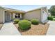 Close-up of the home's entrance showcasing decorative landscaping, neutral paint, and a covered entryway at 2746 Edwards Ln, The Villages, FL 32162