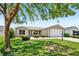 Charming single-story home with a well-manicured lawn and mature shade tree at 2746 Edwards Ln, The Villages, FL 32162