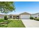 Inviting single-story home with a two-car garage and verdant front lawn at 2746 Edwards Ln, The Villages, FL 32162