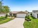 Well-maintained single-story home with a spacious driveway and a manicured front yard at 2746 Edwards Ln, The Villages, FL 32162