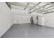 Spacious garage with epoxy flooring, utility sink, new water heater, and white refrigerator at 2746 Edwards Ln, The Villages, FL 32162