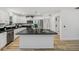 Bright, white kitchen features a large island with black countertop and stainless steel appliances at 2746 Edwards Ln, The Villages, FL 32162