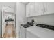 Convenient laundry room with white cabinets, modern washer and dryer, adjacent to kitchen at 2746 Edwards Ln, The Villages, FL 32162