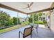 Enclosed patio with a ceiling fan and beautiful landscaping offers a perfect spot for outdoor relaxation at 2746 Edwards Ln, The Villages, FL 32162