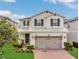 Charming two-story home with a well-manicured lawn and a brick driveway at 2755 Bobcat Chase Blvd, Oakland, FL 34787