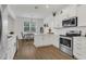 Modern kitchen with stainless steel appliances, white cabinets, and dining area at 2755 Bobcat Chase Blvd, Oakland, FL 34787