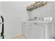 Bright laundry room with a white washer and dryer and shelving for storage at 2755 Bobcat Chase Blvd, Oakland, FL 34787
