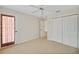 Well-lit bedroom features a ceiling fan, closet, and an exterior door at 2880 Manor Downs, The Villages, FL 32162
