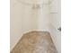 Walk-in closet featuring built-in shelves and tile flooring at 2880 Manor Downs, The Villages, FL 32162