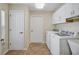 Laundry room with washer, dryer, tile floors, and overhead cabinets at 2880 Manor Downs, The Villages, FL 32162