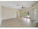 Large tile living room with a ceiling fan and access to the yard through double doors at 2880 Manor Downs, The Villages, FL 32162