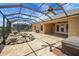 View of the spacious screened-in patio featuring a unique rock water feature and scenic views at 2880 Manor Downs, The Villages, FL 32162
