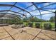 Screened patio with stone flooring and picturesque views of the yard at 2880 Manor Downs, The Villages, FL 32162