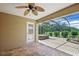 Covered patio showing the patterned floor, ceiling fan, hot tub, and view of the backyard at 2880 Manor Downs, The Villages, FL 32162