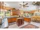 Well-lit kitchen with wood cabinets, an island, and tile flooring at 32511 County Road 437, Sorrento, FL 32776