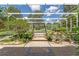 Lush backyard with a screened pool and brick pathway, blending nature and leisure at 32511 County Road 437, Sorrento, FL 32776