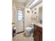 Compact bathroom with a classic white toilet, neutral walls, and an exterior door with a window at 3309 Paisley Cir, Orlando, FL 32817