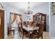 Formal dining room featuring a large table, elegant chandelier, and a classic wood china cabinet at 3309 Paisley Cir, Orlando, FL 32817