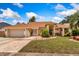 Charming single-story home featuring manicured landscaping, a brick-paved driveway, and a two-car garage at 3309 Paisley Cir, Orlando, FL 32817