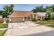 Single-story home boasting a well-maintained lawn, mature trees, and a spacious two-car garage at 3309 Paisley Cir, Orlando, FL 32817