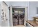 Convenient laundry closet with front-load washer and dryer units and built-in shelving for storage at 3309 Paisley Cir, Orlando, FL 32817