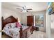 Spacious main bedroom featuring a decorative wood bed frame, ceiling fan, and outdoor views at 3309 Paisley Cir, Orlando, FL 32817