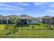Well-maintained backyard with black metal fence, a lush lawn, and an open view of the home's screened in porch at 3467 Buoy Cir, Winter Garden, FL 34787