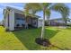 A serene backyard showcasing a covered patio, lush green lawn, and privacy with a view beyond the fence at 3467 Buoy Cir, Winter Garden, FL 34787