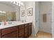 Well-lit bathroom with double sinks, decorative framed signs, and a tiled shower at 3467 Buoy Cir, Winter Garden, FL 34787