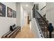 Inviting hallway with tiled flooring, stairs with decorative railing and framed photos at 3467 Buoy Cir, Winter Garden, FL 34787