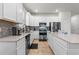 Bright kitchen featuring stainless steel appliances, white cabinets, tile backsplash and a center island at 3467 Buoy Cir, Winter Garden, FL 34787