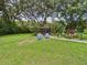 Lush backyard featuring mature trees, a gazebo, two blue chairs, and well-maintained landscaping at 4207 Bair Ave, Fruitland Park, FL 34731
