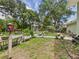 Backyard featuring a white arbor, various potted plants, a small patio area, and green grass at 4207 Bair Ave, Fruitland Park, FL 34731