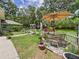 Charming backyard patio with an umbrella-covered table, a white picket fence, and lush landscaping at 4207 Bair Ave, Fruitland Park, FL 34731