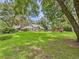 Expansive green backyard with mature trees, a charming gazebo and a glimpse of the house at 4207 Bair Ave, Fruitland Park, FL 34731