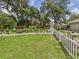 Picturesque backyard with a white picket fence, arbor, lush greenery, and outdoor decor at 4207 Bair Ave, Fruitland Park, FL 34731