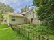 Green house exterior, showing a fenced yard with some grass at 4207 Bair Ave, Fruitland Park, FL 34731