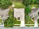 Aerial view of a home with a manicured yard, mature landscaping, and long driveway leading to the street at 4401 Abaco Dr, Tavares, FL 32778