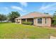 Spacious fenced backyard with a well-maintained lawn and partially covered patio of this home for sale at 4401 Abaco Dr, Tavares, FL 32778