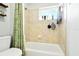 Bathroom featuring shower-tub combo with a tiled surround and window at 4401 Abaco Dr, Tavares, FL 32778