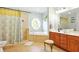 Bright bathroom with a garden tub, shower with a patterned curtain, and a vanity with wood cabinets at 4401 Abaco Dr, Tavares, FL 32778