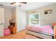 Cozy bedroom with a daybed, hardwood floors, ceiling fan, and natural light from the window at 4401 Abaco Dr, Tavares, FL 32778