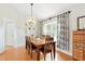 Formal dining room with wood table, modern chandelier, and decorative curtains at 4401 Abaco Dr, Tavares, FL 32778