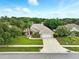 Inviting home with a well-manicured lawn, mature trees, and a paved driveway leading to an attached garage at 4401 Abaco Dr, Tavares, FL 32778